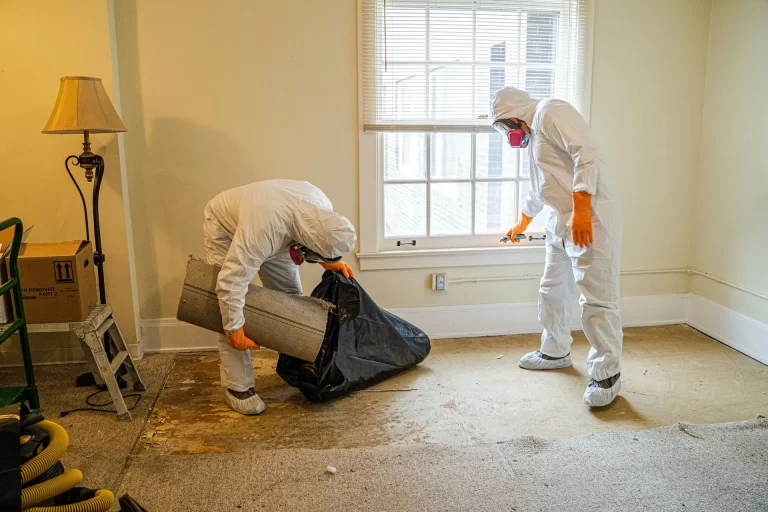 two crime scene cleaners wearing protective gear and cleaning a crime scene