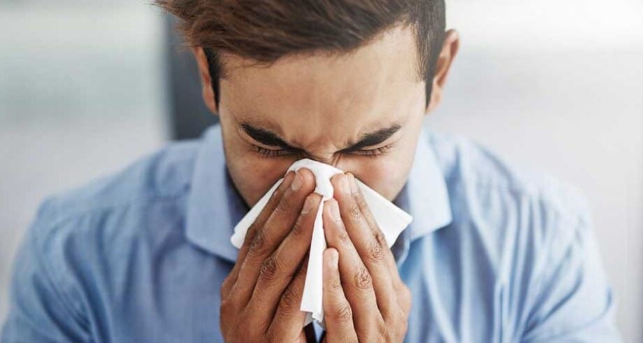 A man sneezes from allergies